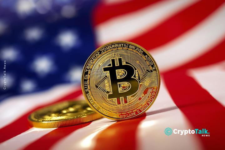A close-up photograph showcasing gold Bitcoin coins, with one coin prominently in focus, slightly tilted towards the viewer. The coin in the foreground is detailed with intricate engraving and a large "B" symbol at its center. A second, partially visible coin lies behind the primary coin, subtly out of focus. The coins are set against a blurred backdrop featuring the red and white stripes and blue section with stars of the American flag. The lighting is bright and focused, highlighting the metallic sheen of the gold coins. The composition utilizes a shallow depth of field, emphasizing the texture and details of the coins while providing context with the patriotic background. The overall style is realistic, conveying a sense of value and economic significance. The perspective is from a slightly low angle.
